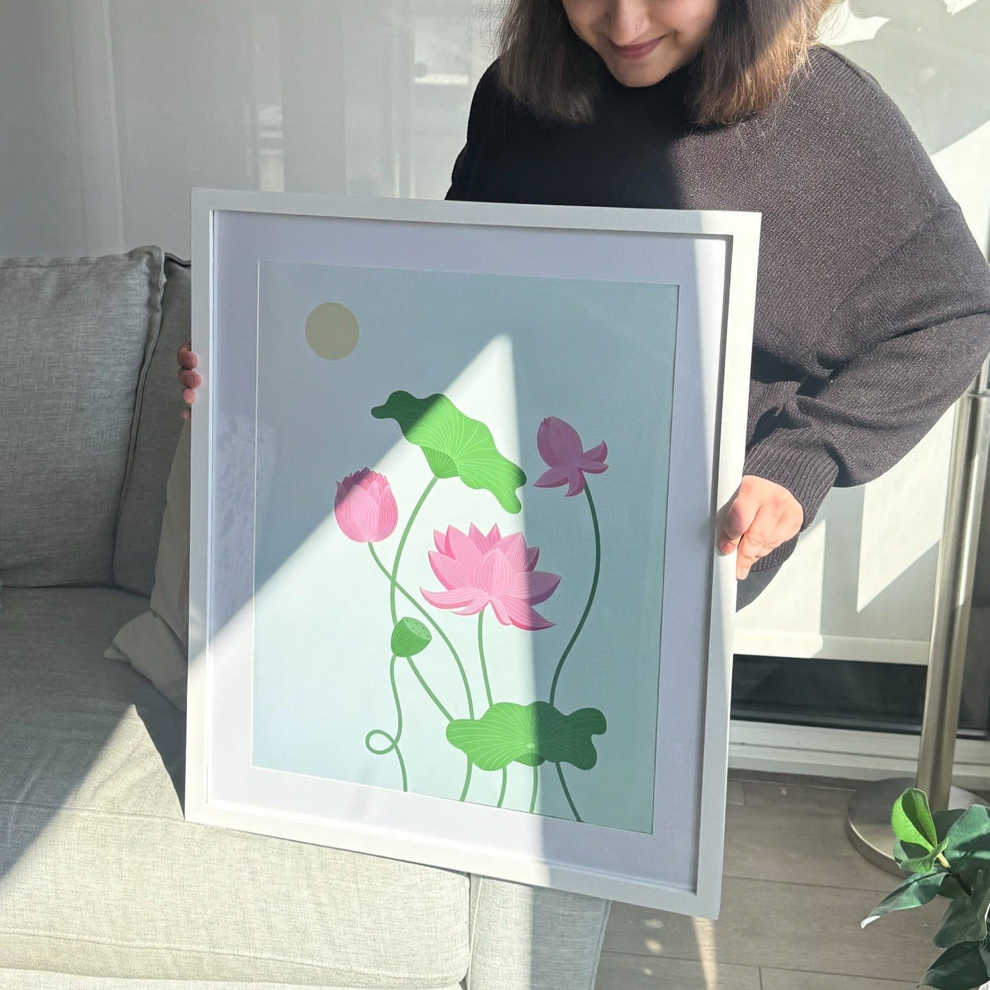 Framed Lotus Wall Art - A soft and luminous floral art print, featuring a peaceful lotus floating gently on a pastel blue background