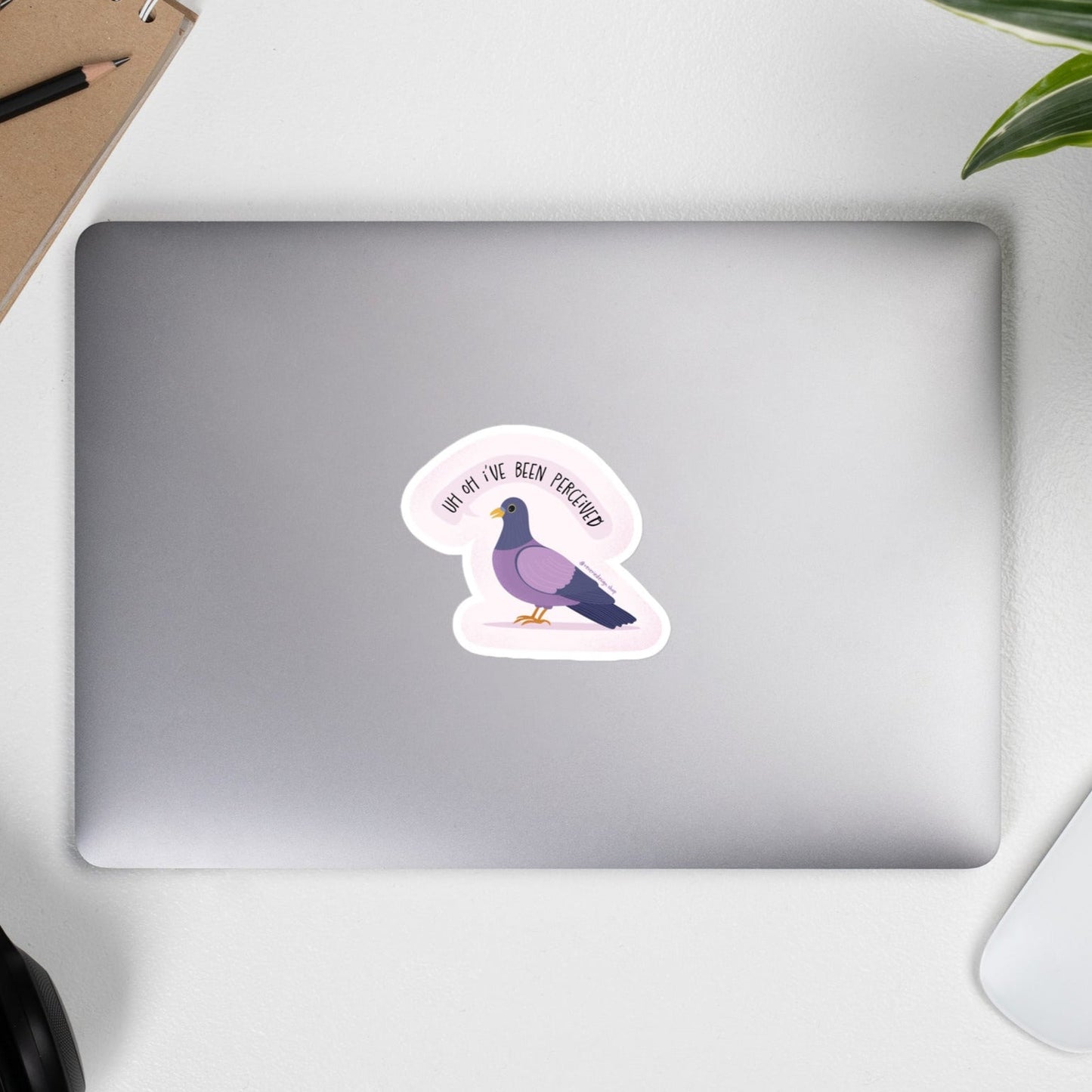 Matte vinyl pigeon sticker on a laptop with panic expression and caption "Uh Oh I’ve Been Perceived"
