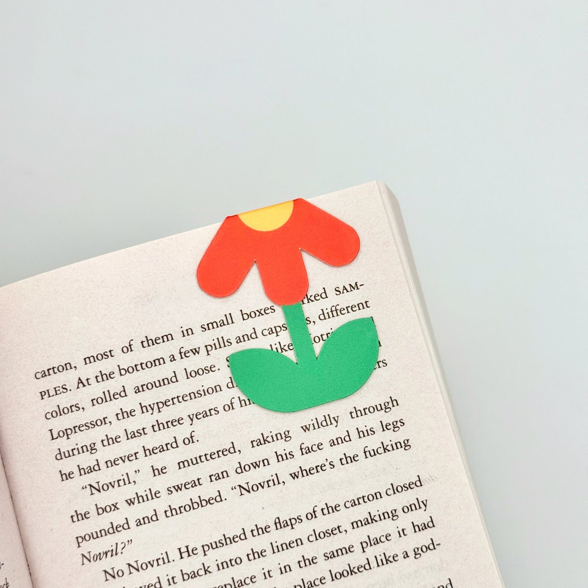 Orange daisy magnetic bookmark folded over book page