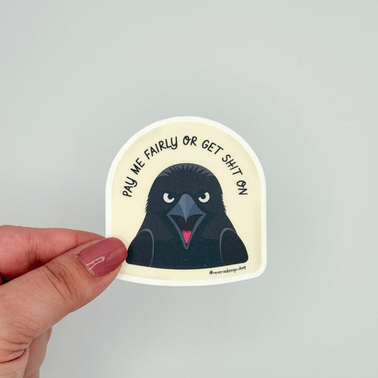 Funny protest crow sticker for workplace and political humor with text ‘Pay me fairly or get shit on’